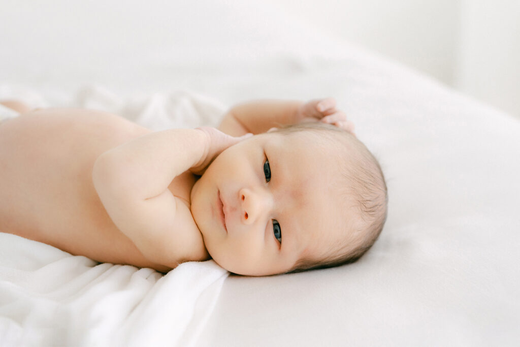 A newborn looks at the camera for a portrait.