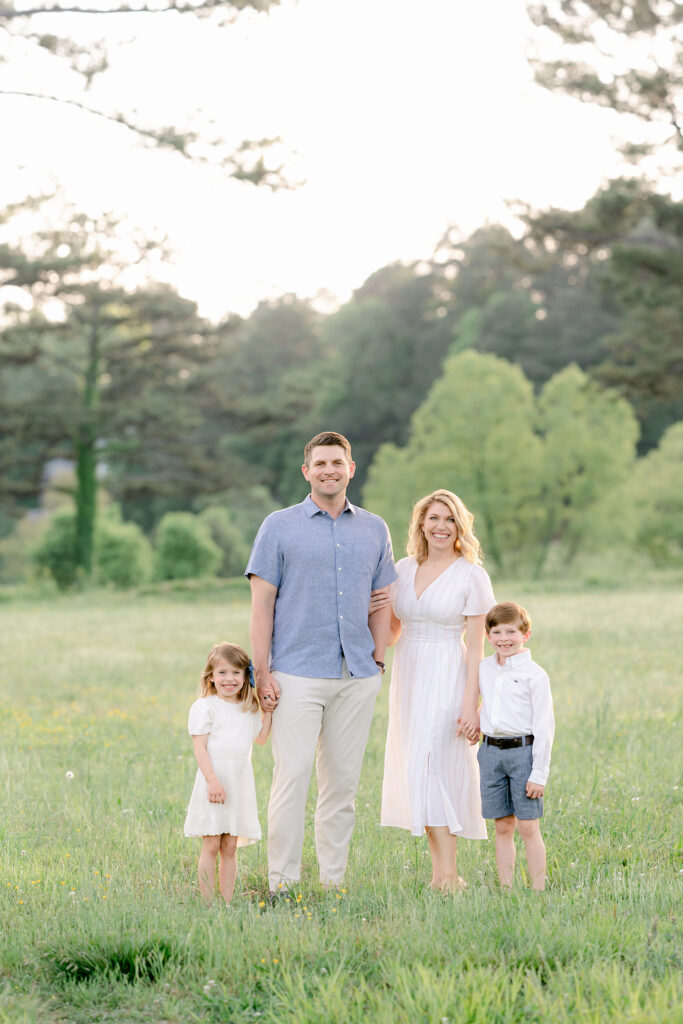 family of 4 pose during a family photography session outdoors in the Spring