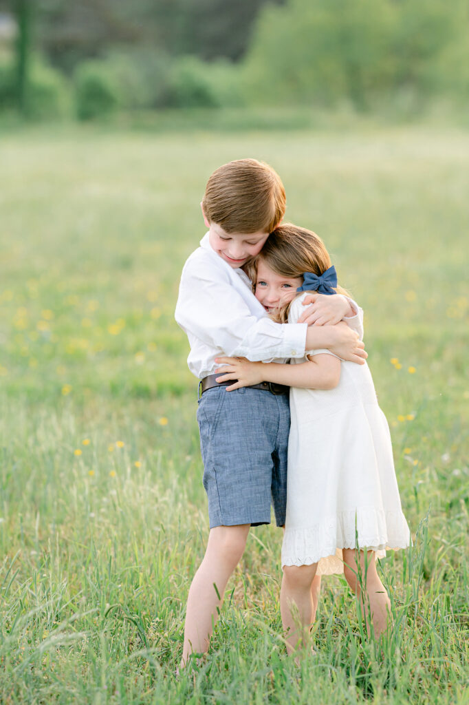 a young boy and his sister embrace lovingly