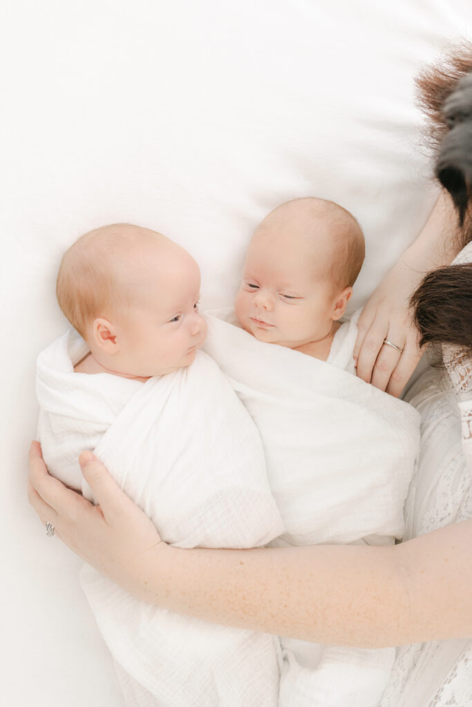 Twin, newborn, girls in mom's hands.