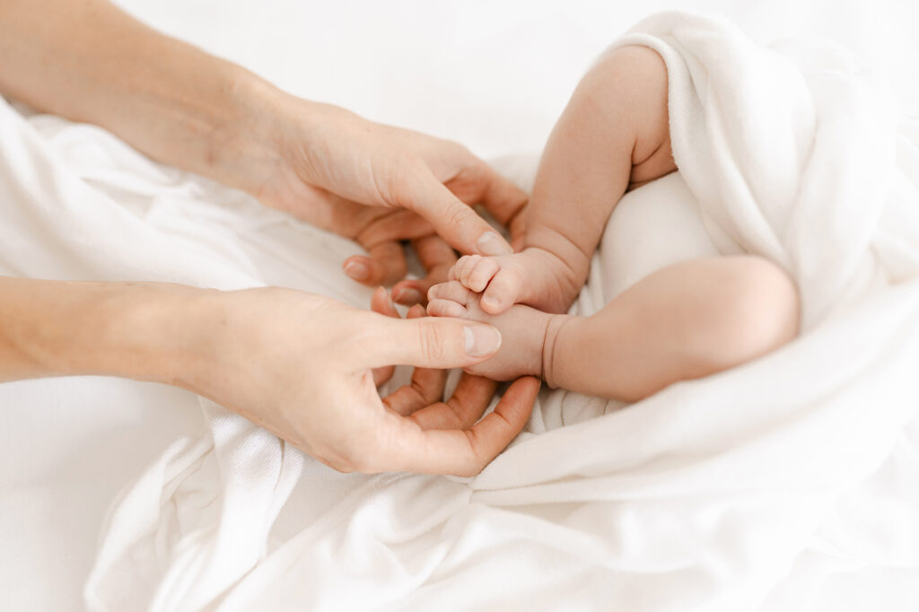 a new mom holds her babys feet